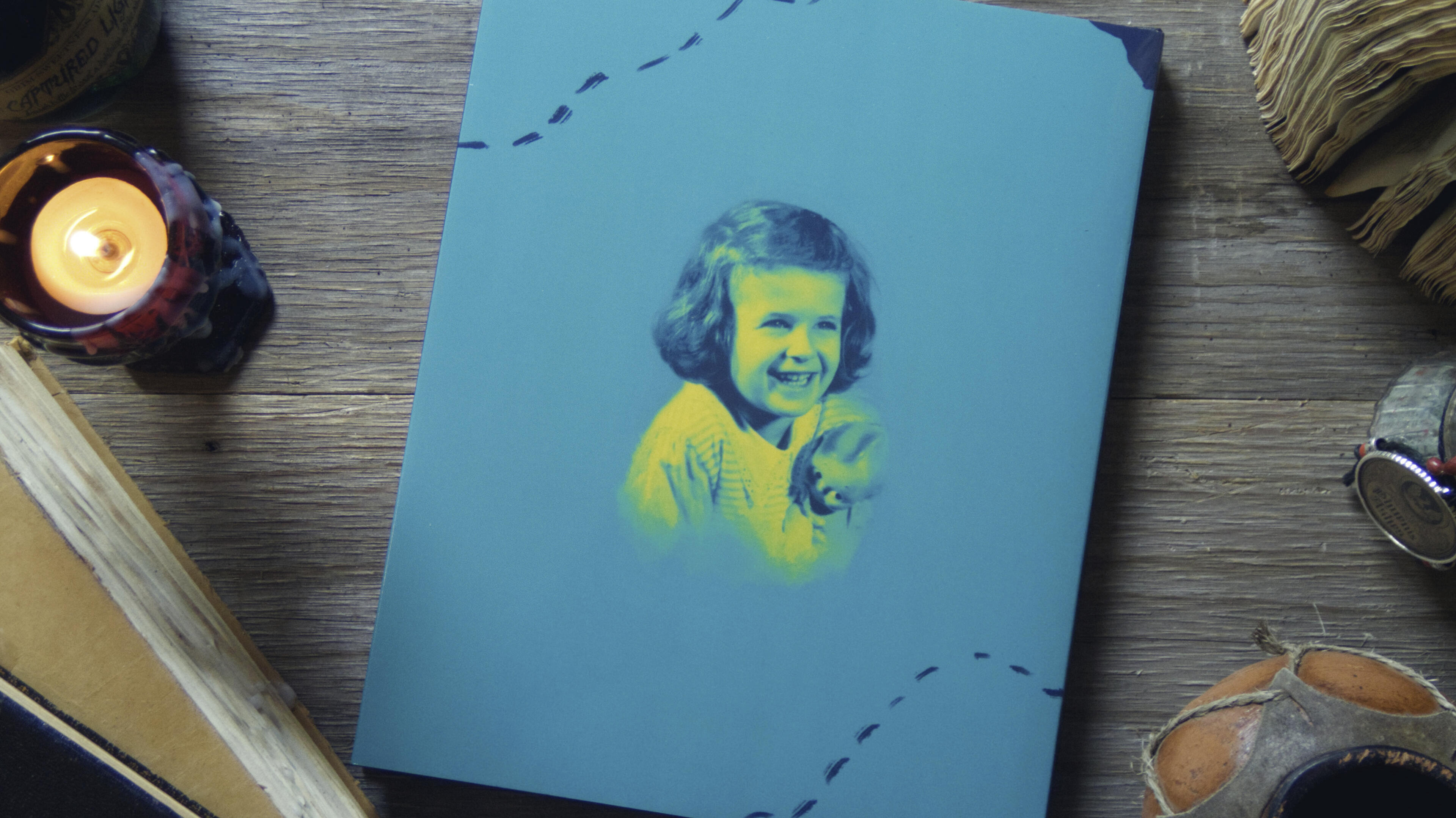 Brenda Turner (Back) Back of Brenda's book. A picture of her as a child leaps out of the teal background. She smiles.