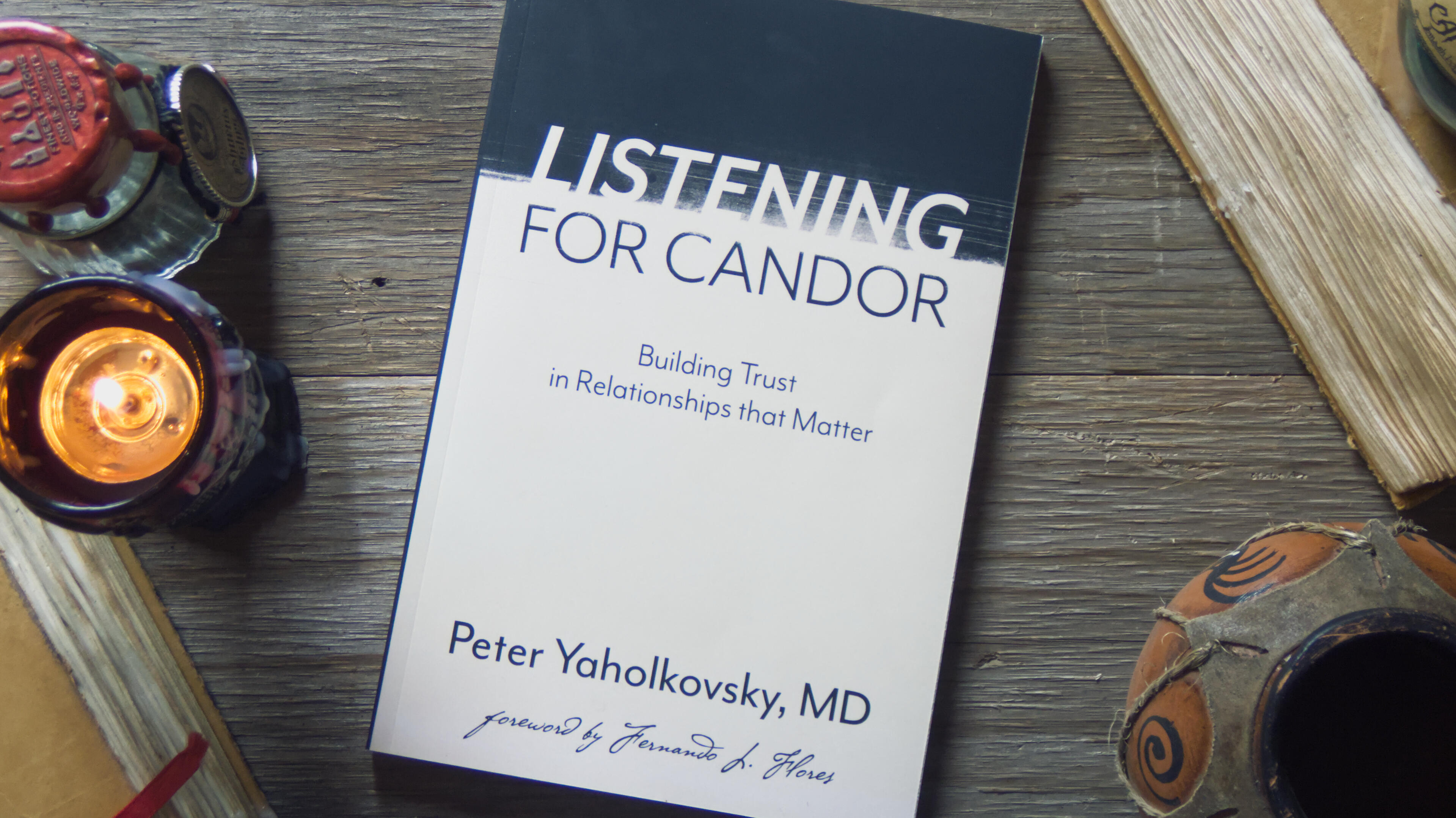 Similar showcase of a paperback. A sober design with a distressed treatment of the title text: Listening for Candor, Building Trust in Relationships that Matter. Peter Yaholkovsky, MD. Foreword by Fernando L. Flores